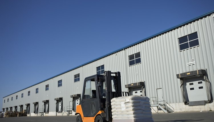 Forklift with stack of bags in front of warehouse