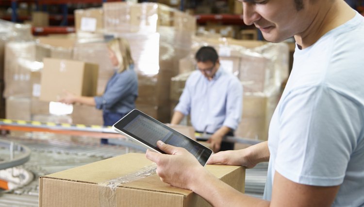 Worker Using Tablet Computer In Distribution Warehouse