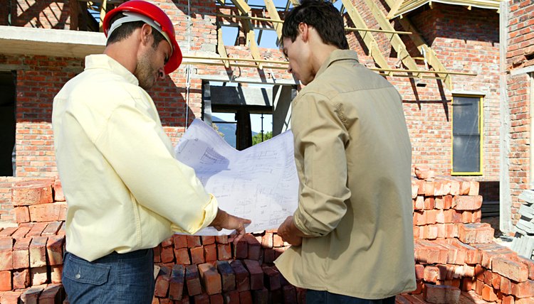 Contractor and client examining blueprints