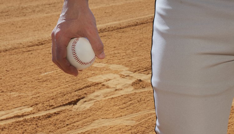 Man holding baseball, mid section