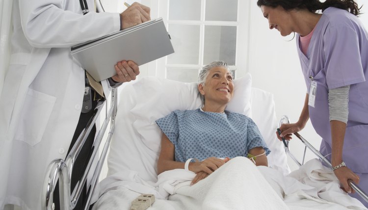 Patient in hospital bed speaking to Doctor and Nurse