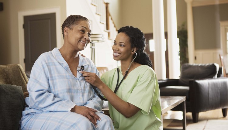 Nurse using stethoscope on patient at home