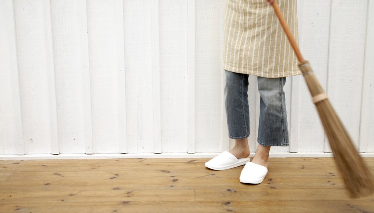 Woman sweeping floor using Japanese style broom in home