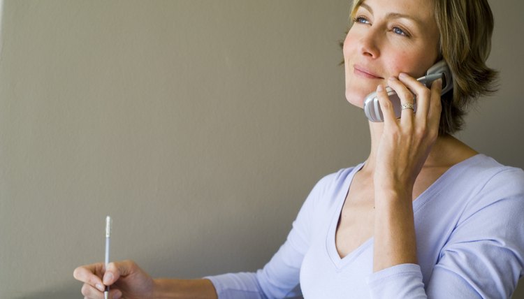 Woman talking on phone and writing