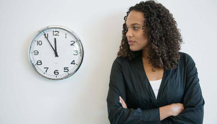 Pensive businesswoman looking at clock