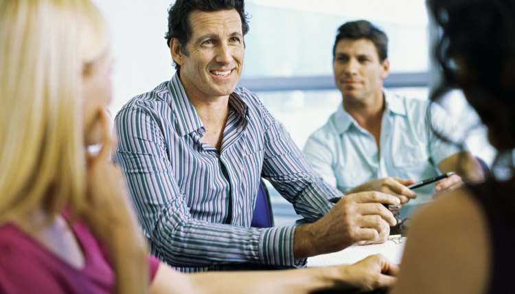 Side view of three mid adult people sitting and talking