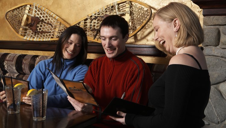 Man and woman ordering from waitress in pub