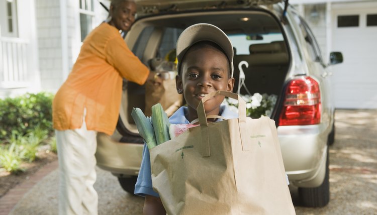 Smiling woman and boy with groceries