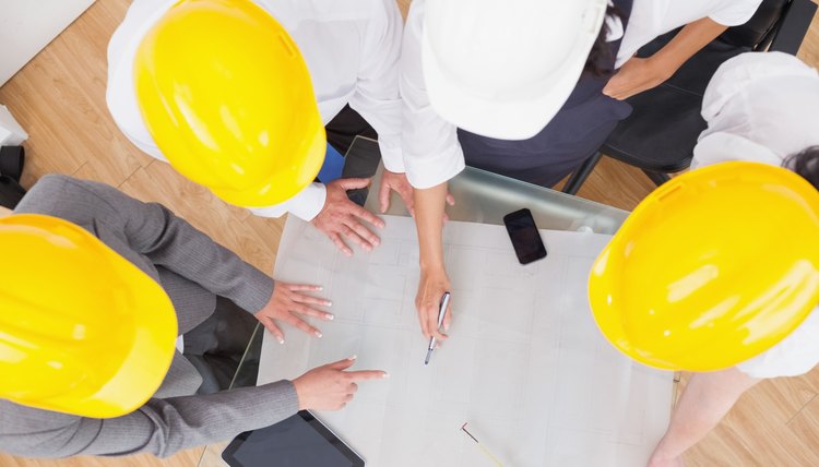 Team looking at a construction plan with hard hats