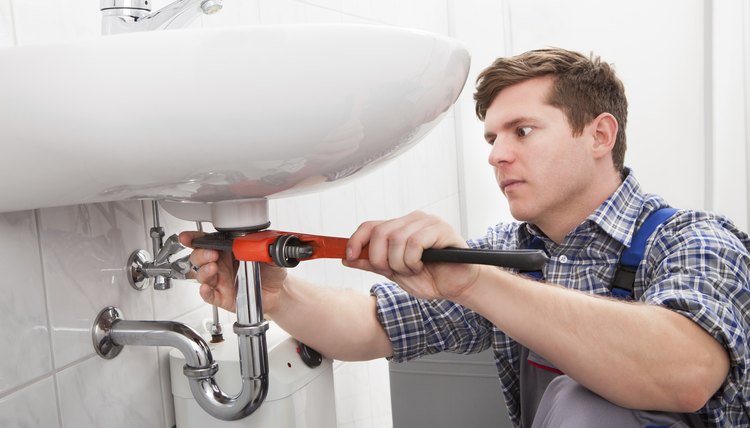 Portrait of male plumber fixing a sink