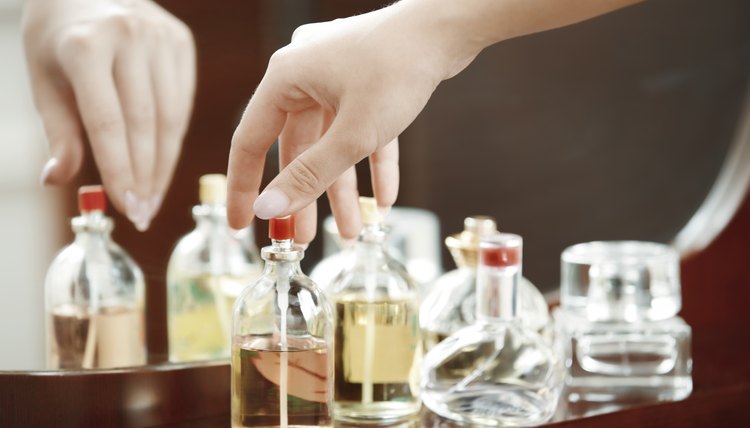 Hands of woman selecting and testing perfume