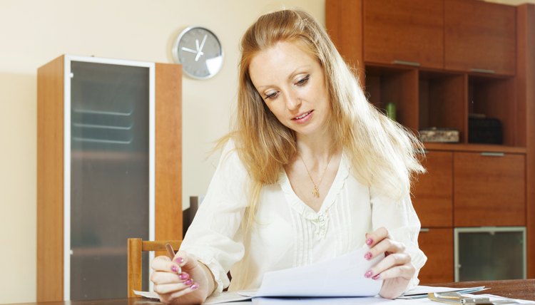 serious blonde woman looking financial documents