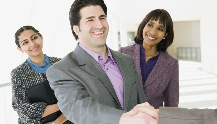 Businesspeople greeting colleague
