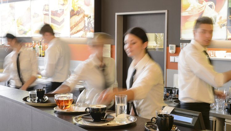 Busy waiter and waitresses working at bar