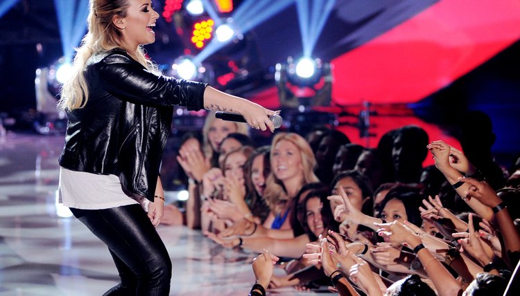 Demi lovato performs in a black leather jacket and matching leather pants