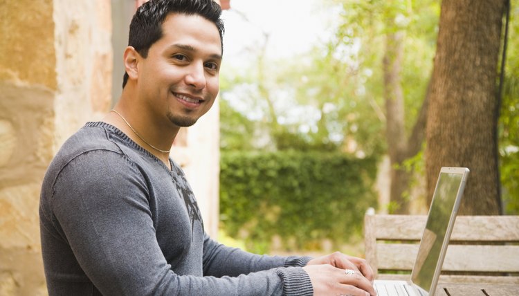 Man working on a laptop and smiling
