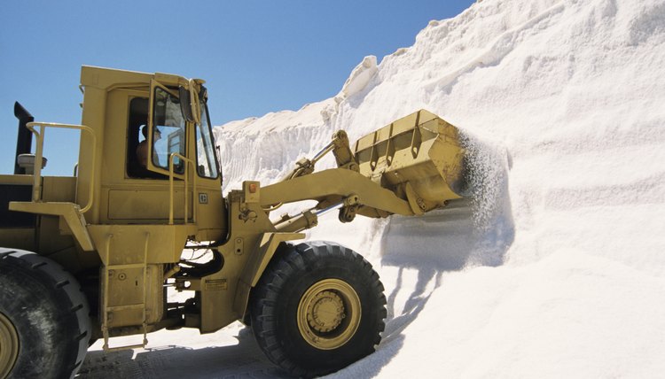 Bulldozer truck loading salt at refining plant, Spain