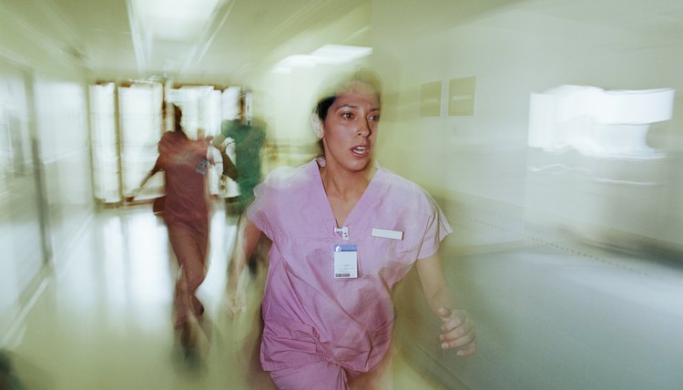 Nurse running down hospital hallway, blurred motion
