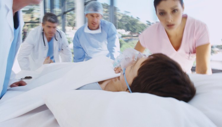 Close-up of medical personnel taking a female patient into surgery