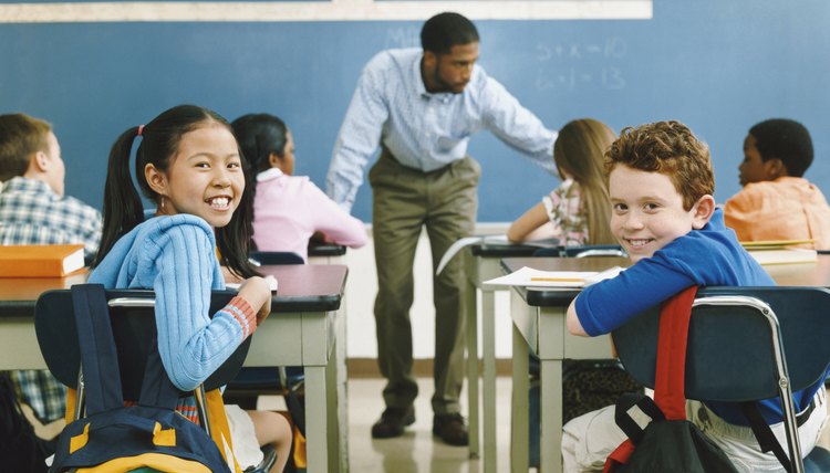 Two Smiling Children Sitting at the Back of a Primary School Class