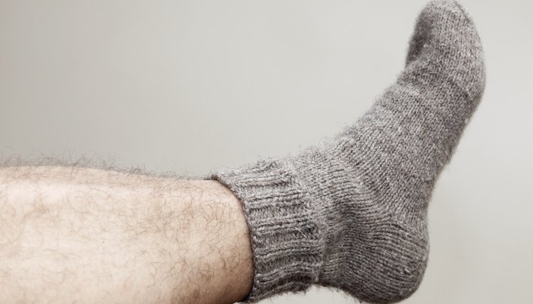 Closeup photo of male foot with gray woolen sock