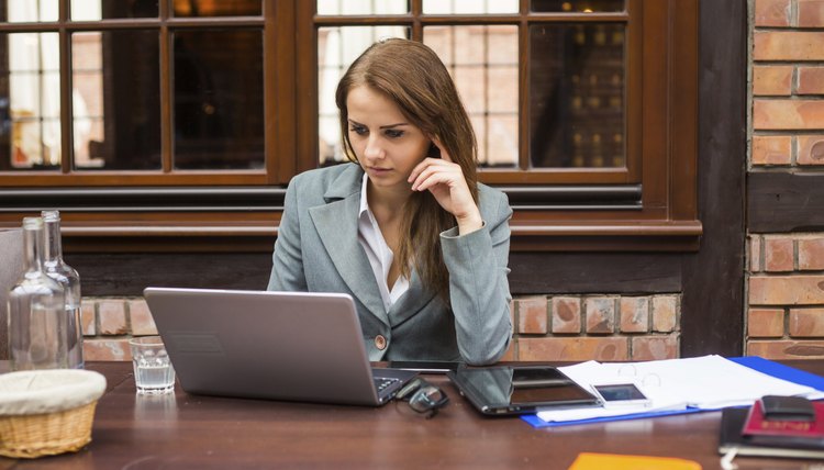 Hard working businesswoman in restaurant with laptop.