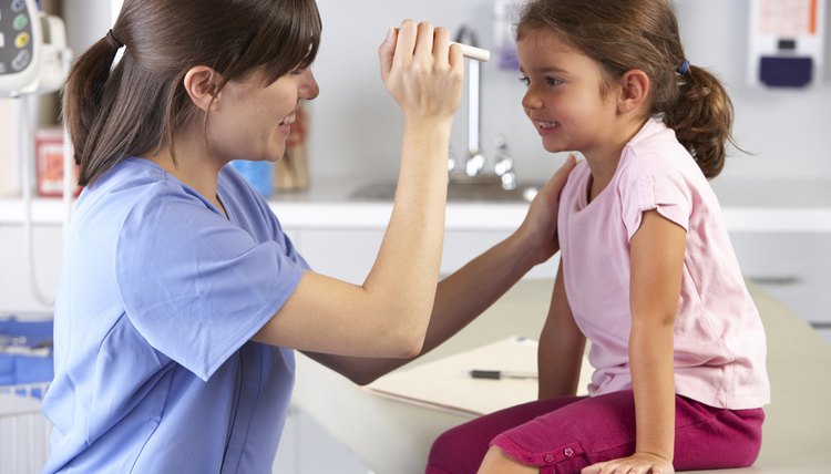 Doctor Examining Child's Eyes In Doctor's Office