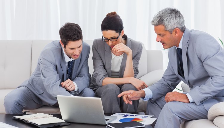 Business people using laptop and working together on sofa