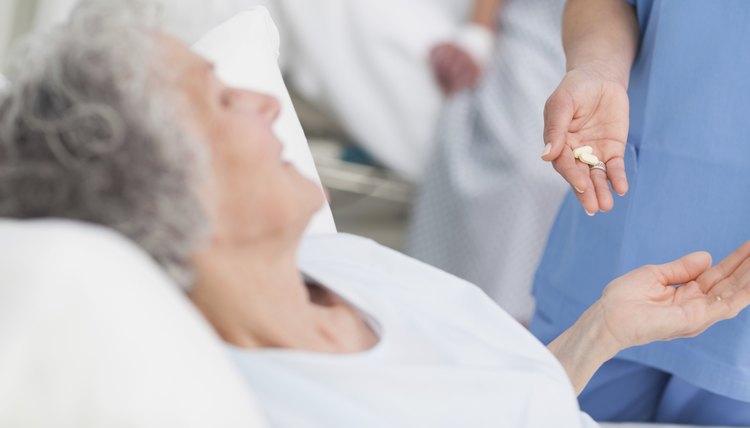 Nurse giving drugs to an elderly patient