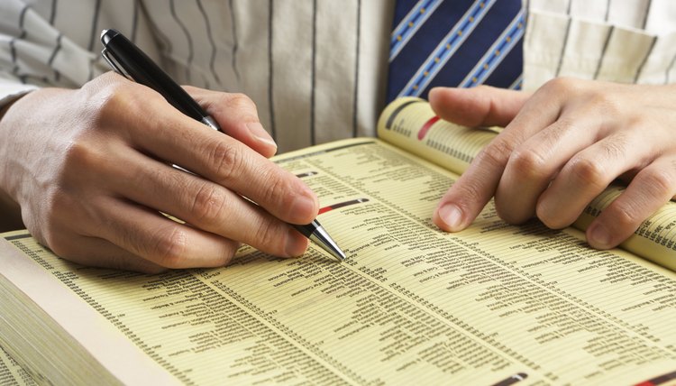Businessman searching in yellow pages
