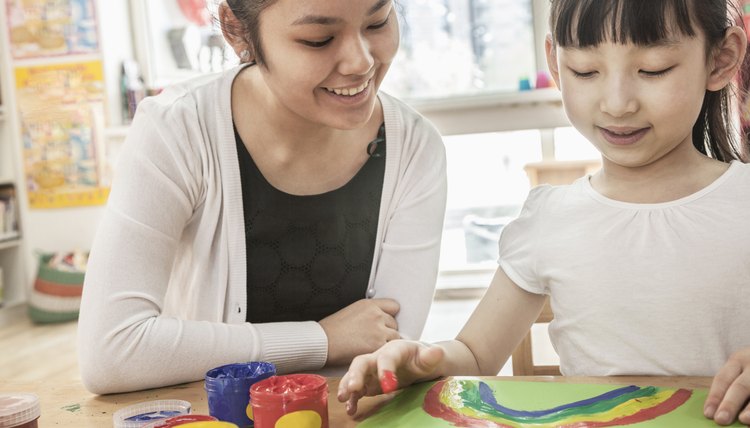 Teacher and student finger painting in art class
