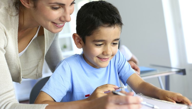 Smiling teacher helping kid