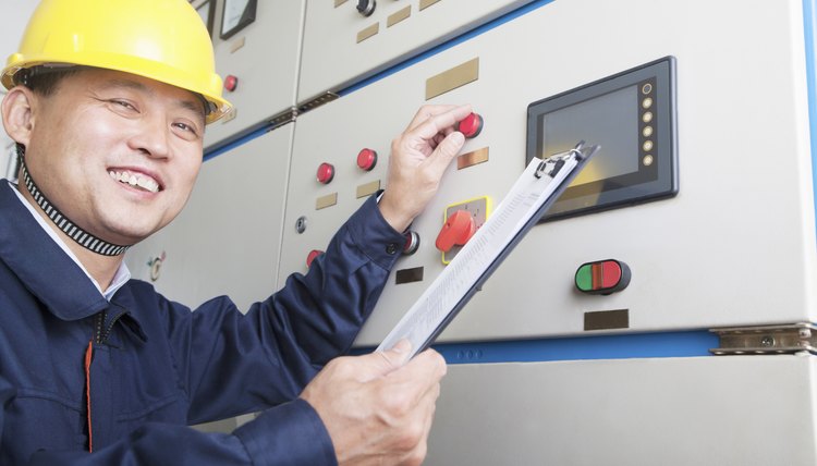 Portrait of smiling worker checking controls in a gas plant,