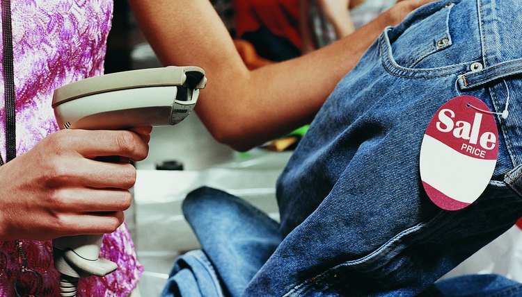 Close up of a Shop Assistant Scanning the Price Tag on a Pair of Jeans at the Checkout Counter of a Clothes Shop