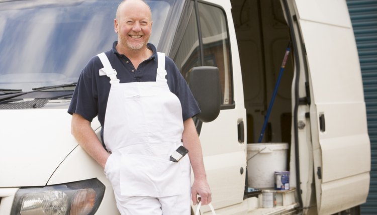 Painter standing with van smiling