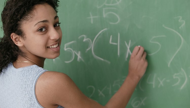 Teenage girl writing on chalkboard