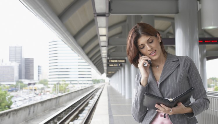 Young woman talking on a mobile phone at a train station
