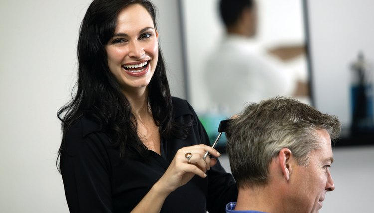 Woman cutting hair of man