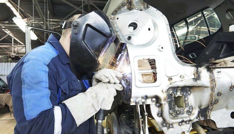 repairman welding metal body car