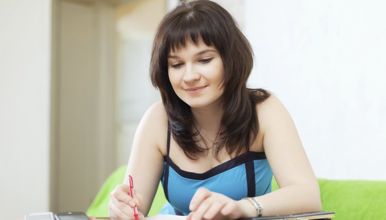 serious housewife fills in utility payments bills