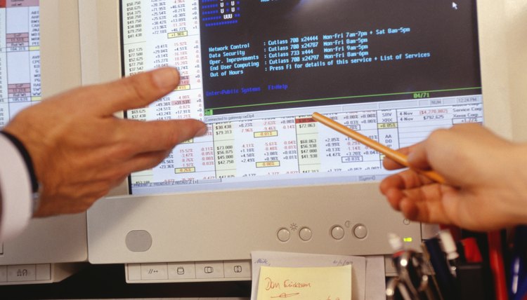 Two people viewing computer screen in trading room