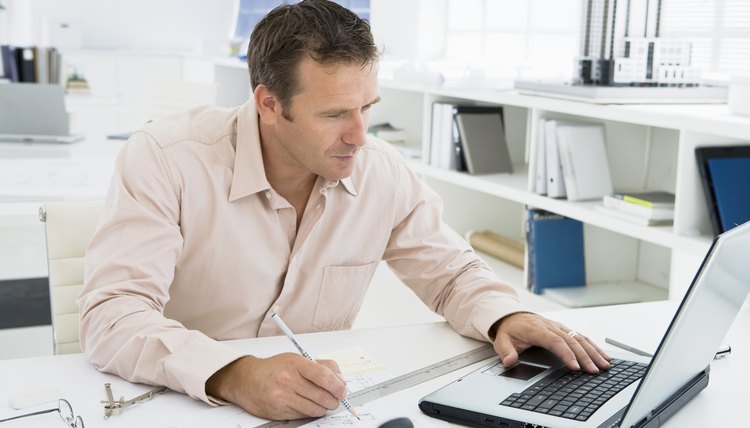 Man working on laptop in architectural office