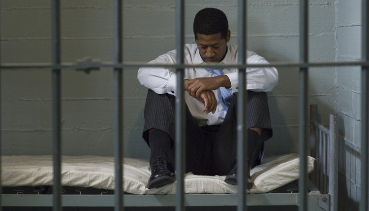 Prisoner sitting in his prison cell