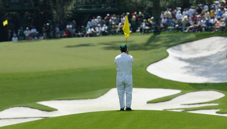 A forecaddie marks a ball's position during the 2004 Masters.