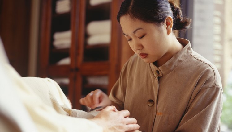 Young woman making manicure in beauty parlour, surface view
