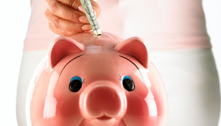Woman putting money into piggy bank