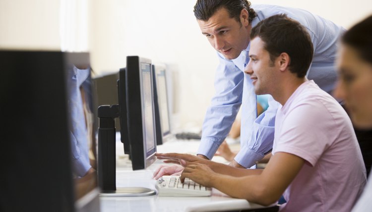 Man assisting other man in computer room