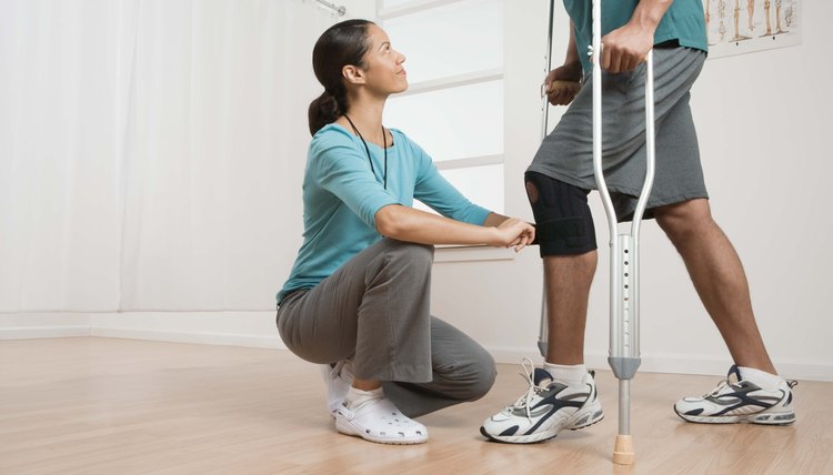 Physical therapist helping patient with crutches