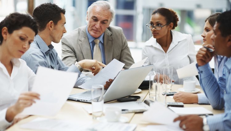Business people discussing work on laptop at a meeting