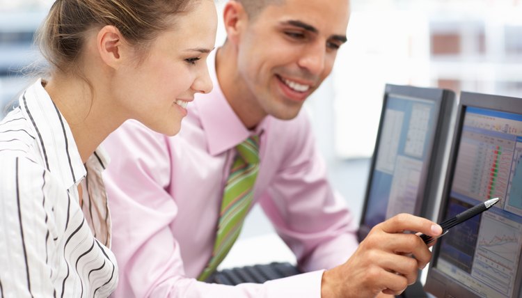 Businessman and woman working on computers